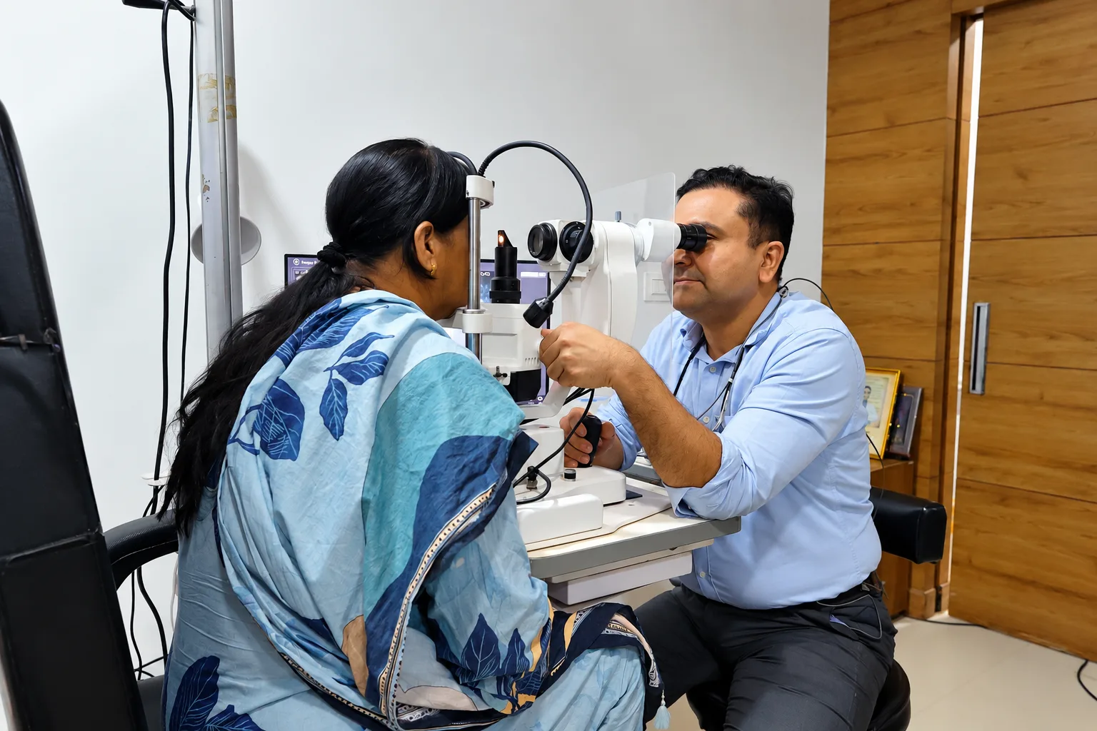 Eye specialist examining a patient with a slit lamp